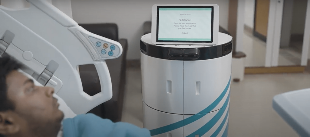 Robot delivering medicine to a patient lying in a hsopital bed